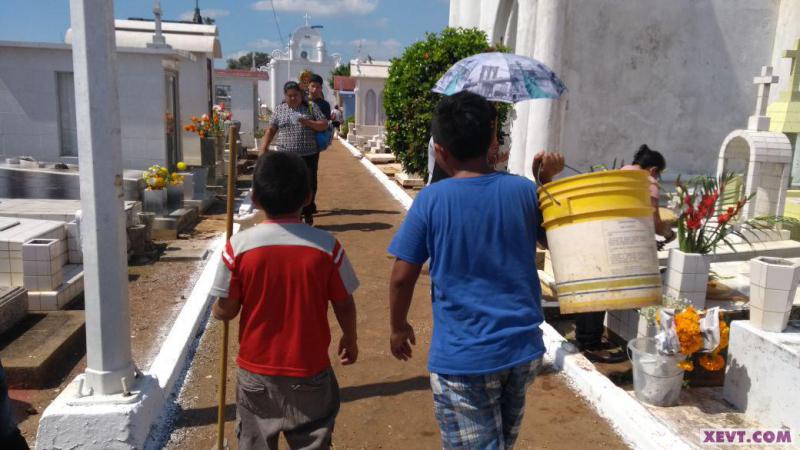 Niños cambian lápiz y cuaderno por cubeta y trapeador para lavar tumbas en el Panteón Central de Villahermosa