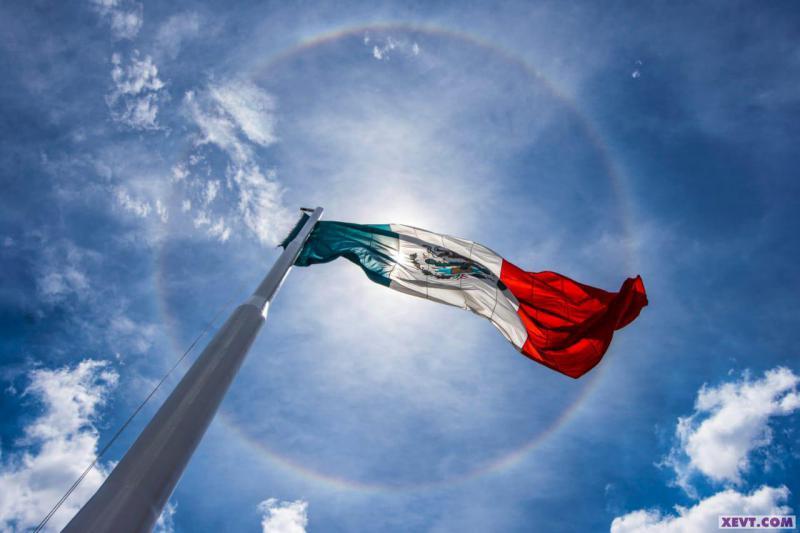 Imagen del Día: Hermosa bandera mexicana ondea bajo gigantesco halo solar