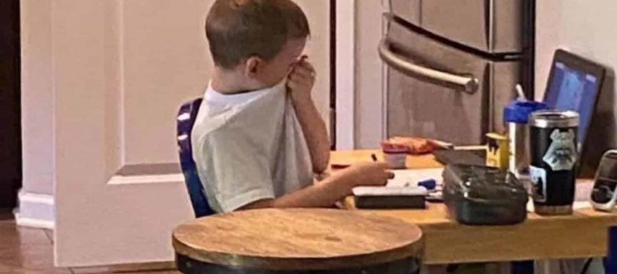 Niño llora frente a la computadora con frustración ante las clases virtuales
