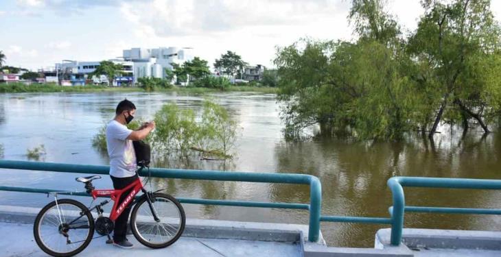 Curiosos se asoman a documentar el alto nivel de aguas del Grijalva