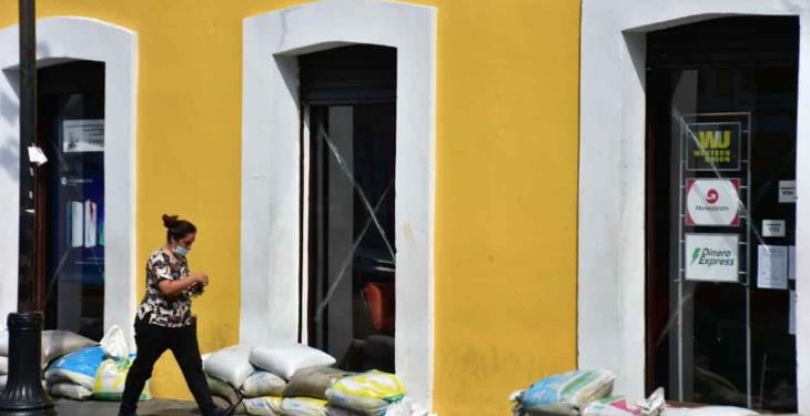 Por precaución, comercios dejan costalería en sus entradas