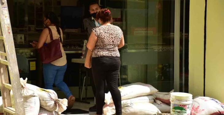 Por precaución, comercios dejan costalería en sus entradas