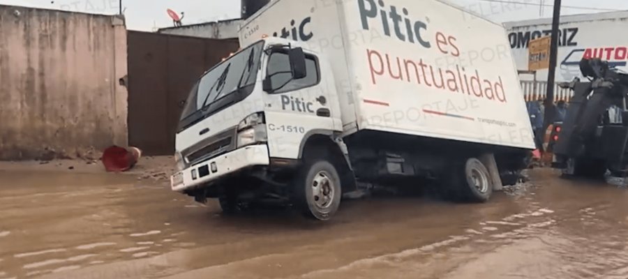 Camión de paquetería cae en socavón en el Periférico