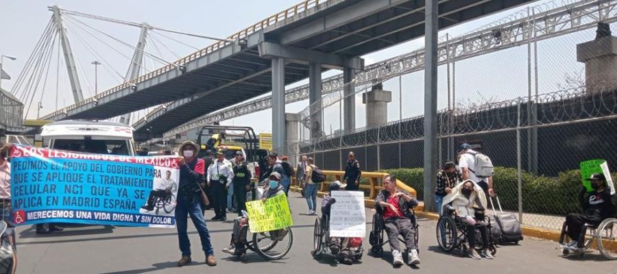 Personas en sillas de ruedas bloquean accesos a Terminal 1 del AICM