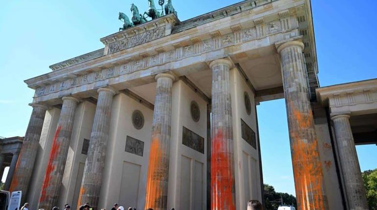 Activistas pintan Puerta de Brandeburgo en Berlín durante protesta