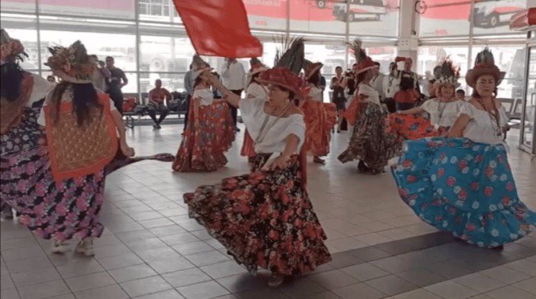 Danzantes del Pochó llenan terminal de ADO con colorida mezcla de flores, máscaras y hojas secas