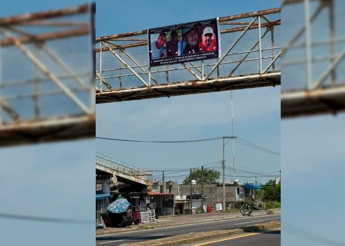 Familiares de mecánicos desaparecidos cuelgan lona en puente peatonal de Dos Montes